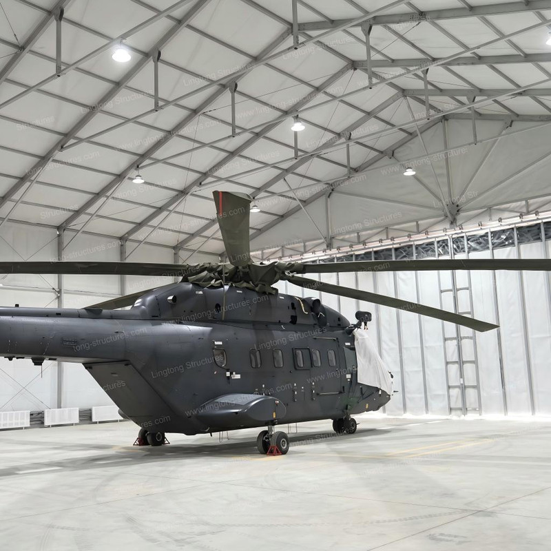 Private aircraft hangar tent providing all weather protection for private planes and helicopters near airfield