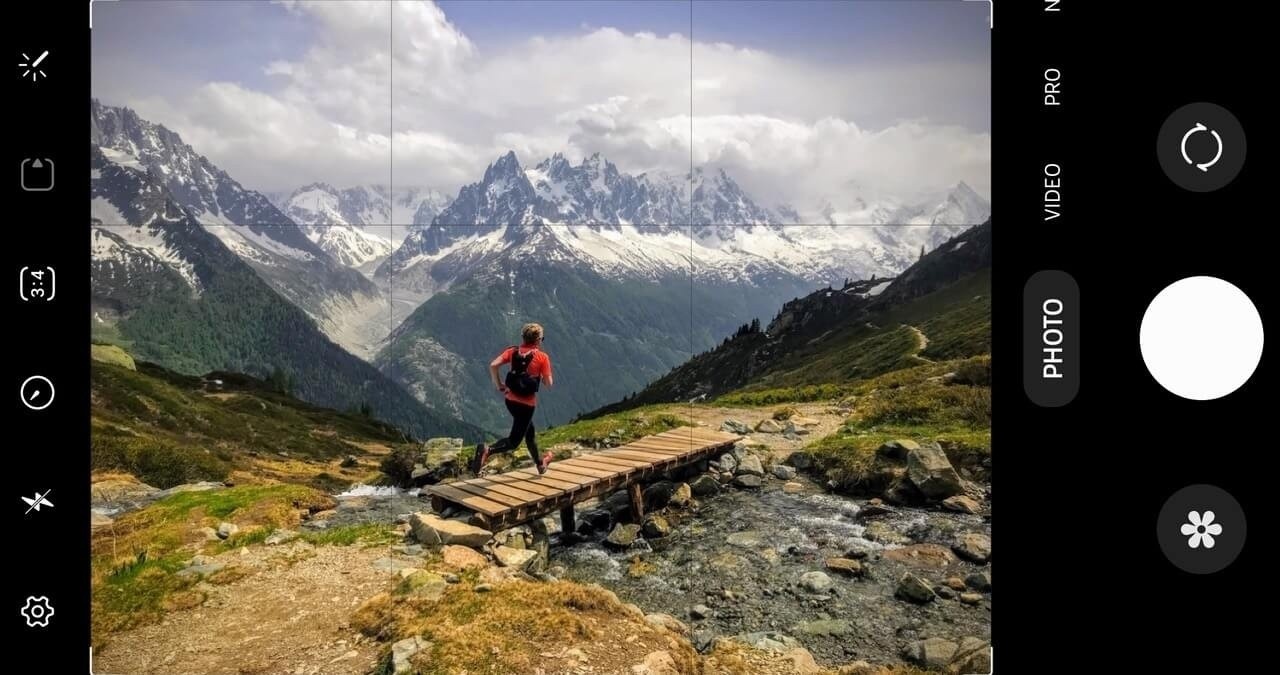Câmera de celular com sobreposição de interface em uma foto de uma pessoa em uma ponte nas montanhas