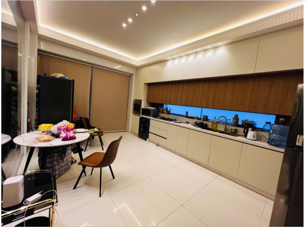 مطبخ واسع مع سفرة داخلية في فيلا فاخرة بعجمان، يتميز بتصميم عصري ومساحة كبيرة مثالية للعائلات.