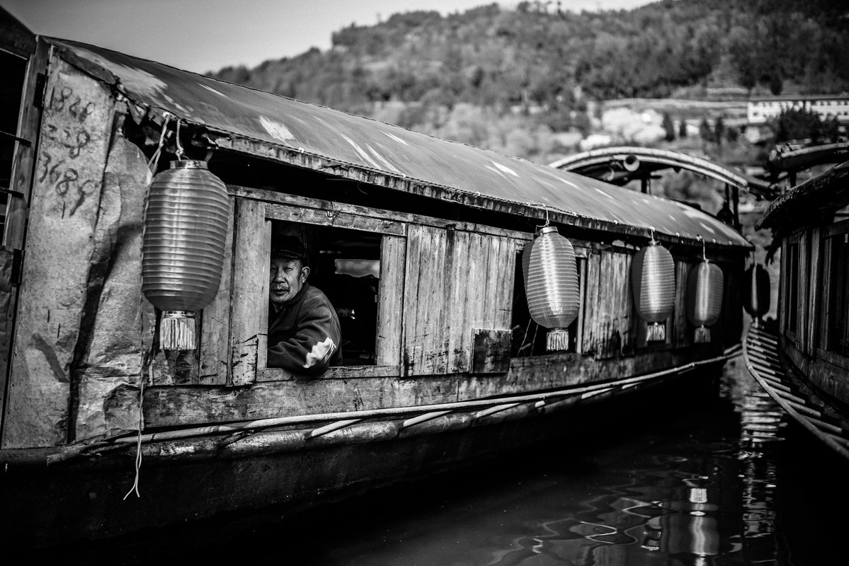blacknwhitemanonwoodenboat.jpg