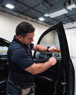 SunTek Evolve Ceramic window tint being applied to front two windows of a vehicle