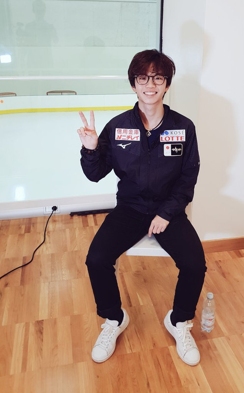Kazuki Tomono in glasses flashing a peace sign