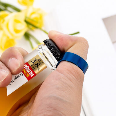 Persona usando el anillo abridor para destapar una botella.