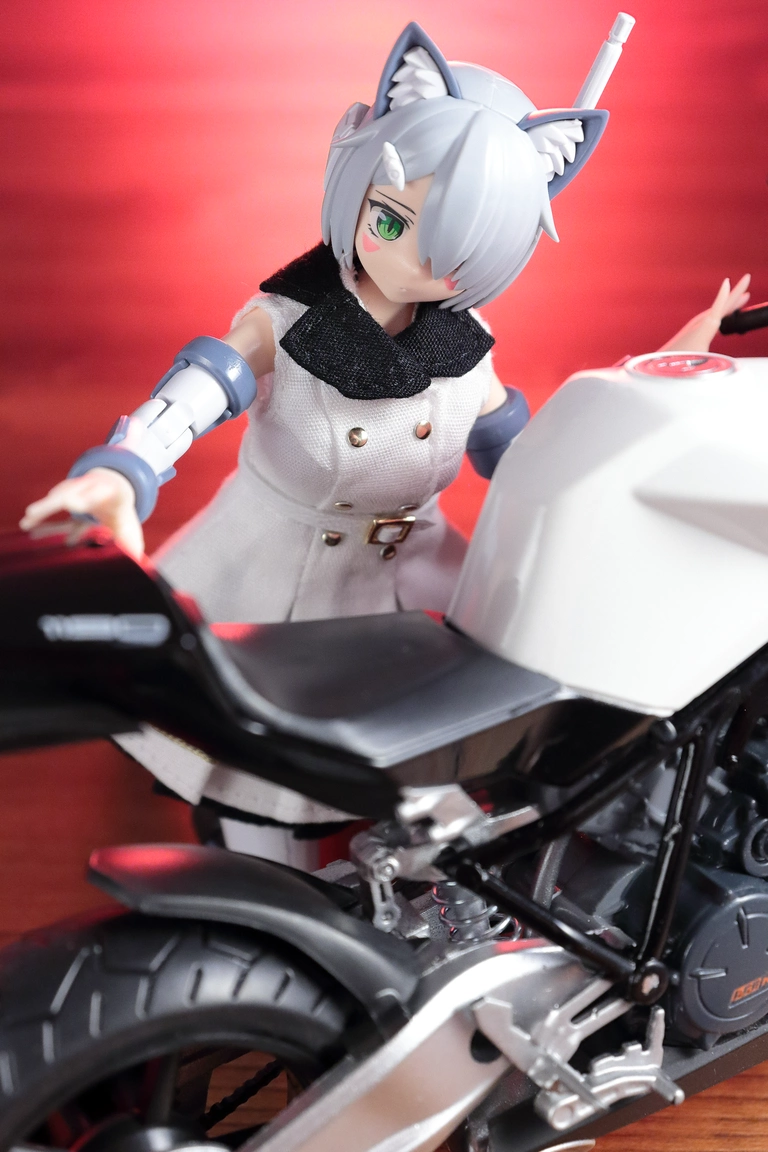 A close-up view of a 1:12 scale diecast model of the RC8 in white and “Variable Fighter Girls” Kairos girl wearing the dress from a 1/12 Military One-piece Dress Set in white and black