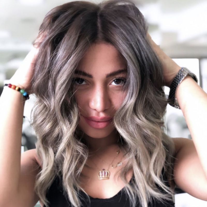A girl with her hands in her ash blonde hair