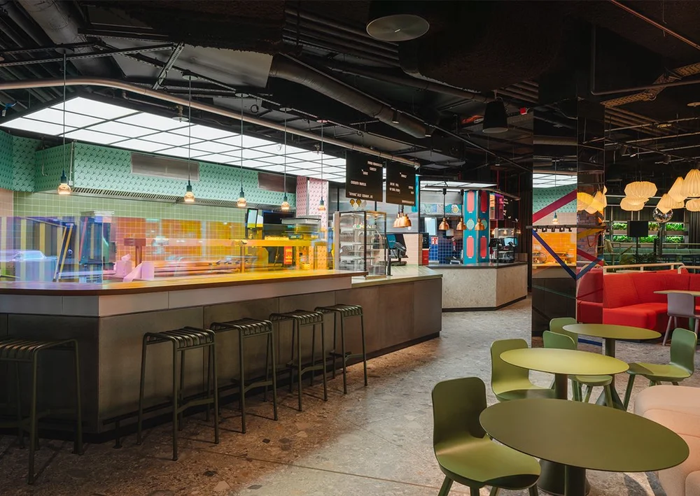 Illuminated food counters, bar seating and shared dining space at Le big TamTam in Hamburg