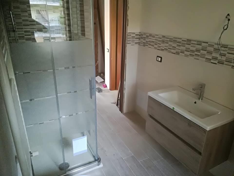 Bagno su misura con rivestimenti naturali, doccia walk-in e rubinetteria design