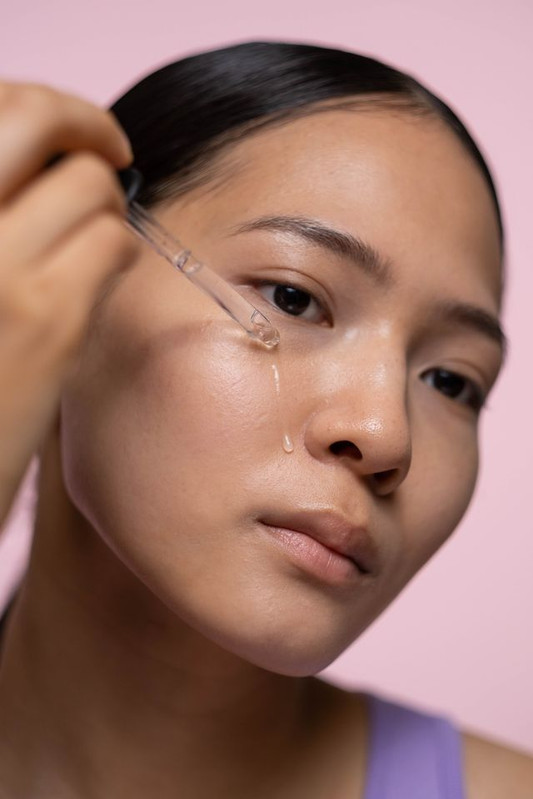 a woman using hyaluronic acid serum to make her skin hydrated, soft, supple and plump 