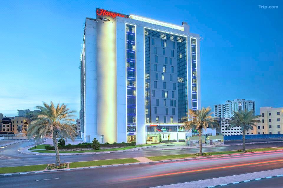 الواجهة الخارجية لفندق Hampton by Hilton Dubai، بتصميم عصري وموقع استراتيجي قريب من أبرز معالم دبي ومطارها الدولي.