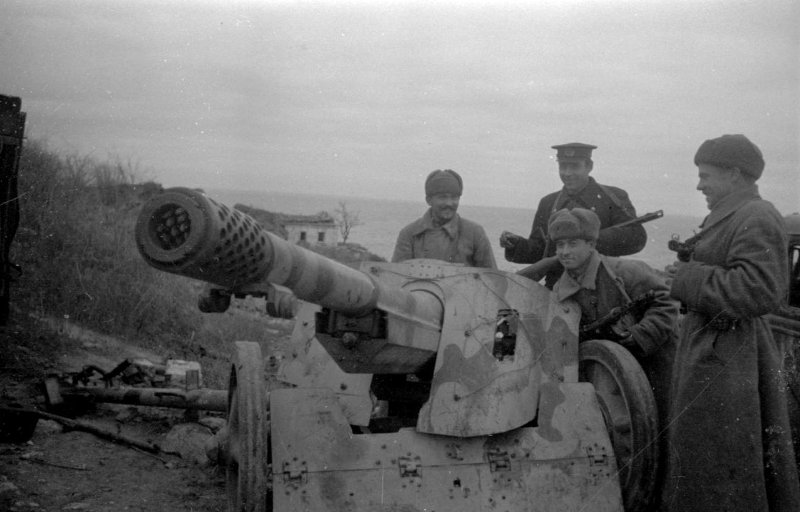 Бойцы морской пехоты группы старшего лейтенанта Стафийчука осматривают трофейную немецкую пушку.