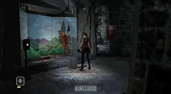 Lara mirando los juegos mecánicos en un museo abandonado. Lara Croft observando una maqueta de juegos mecánicos de un museo abandonado en Inglaterra y en la que se representa al rey Arturo y al mago Merlín