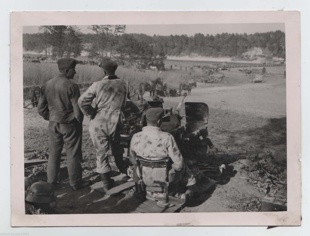 deutsche Landser in Tarnung mit Geschütz am Flussübergang