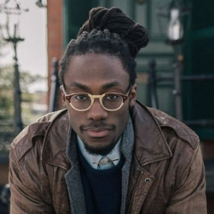 Handsome Black male model with locs and glasses as Face Claim for James