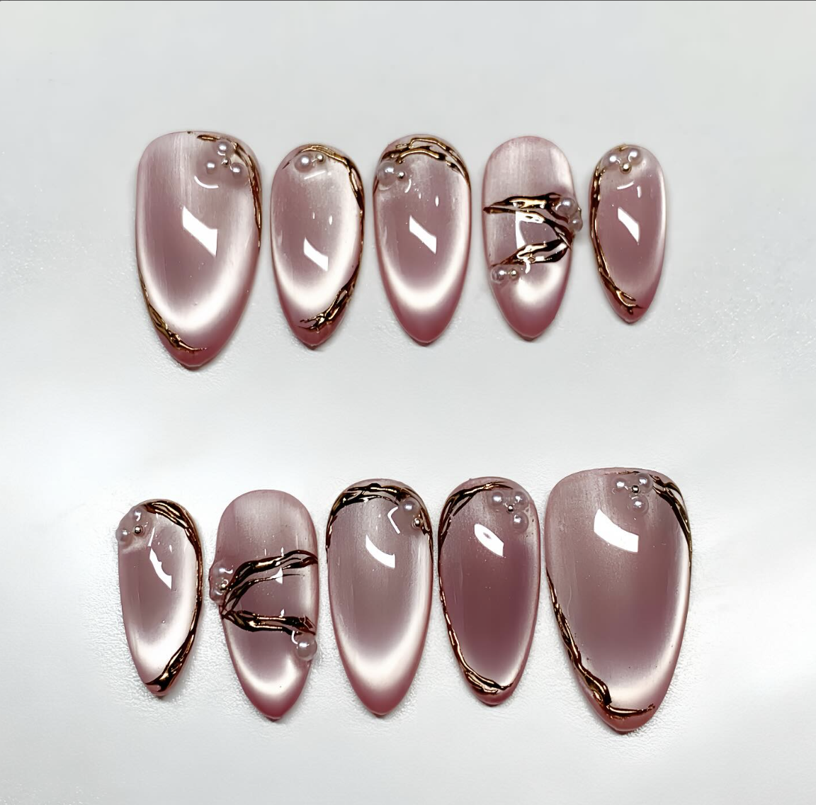 Set of Niice press-on nail designs arranged on a soft pink background