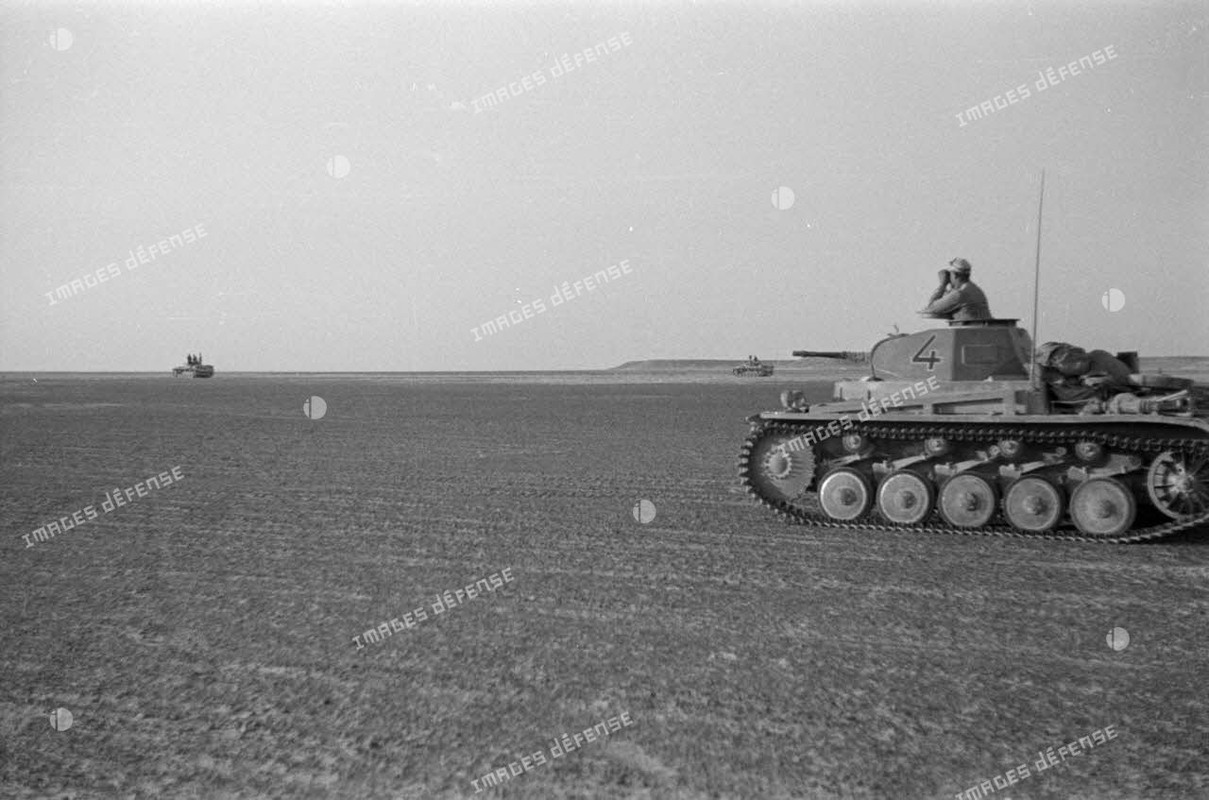 Un char léger Panzer II (Pz-II Ausf-B) à l'arrêt, le chef de char observe à la jumelle, derrière deu