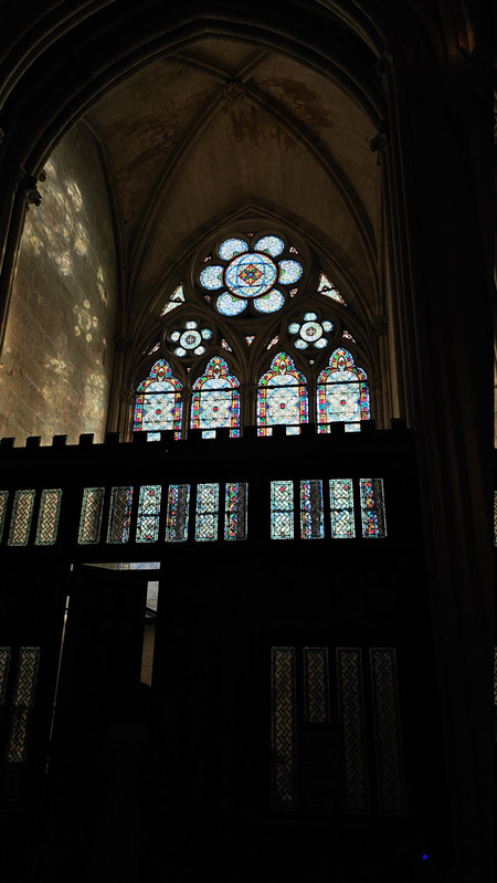 下午陽光穿過彩繪玻璃映在石牆上