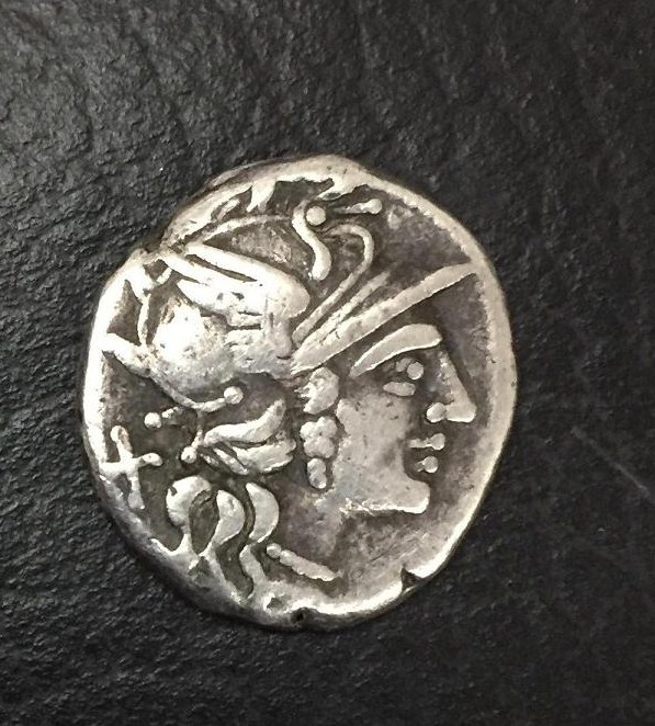 Cabeça de Roma com capacete alado, olhando para a direita. Atrás