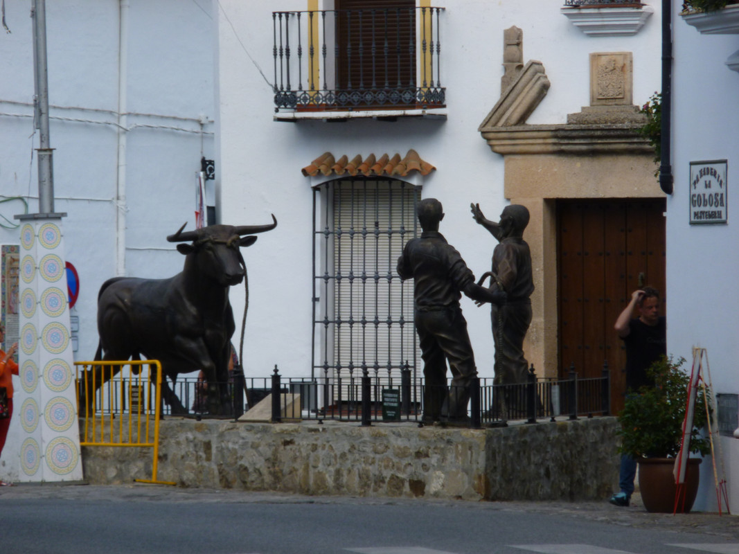 Statue is two men in front of a bull.  The bull has got loose from the rope holding it.  The figures look like they are about to try to run away.