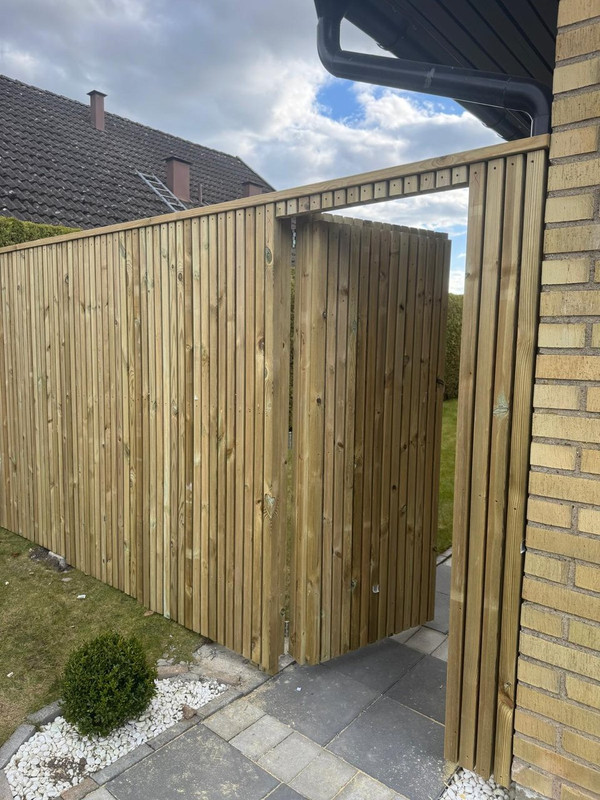 Garden landscaping with wooden pergola and fence installation