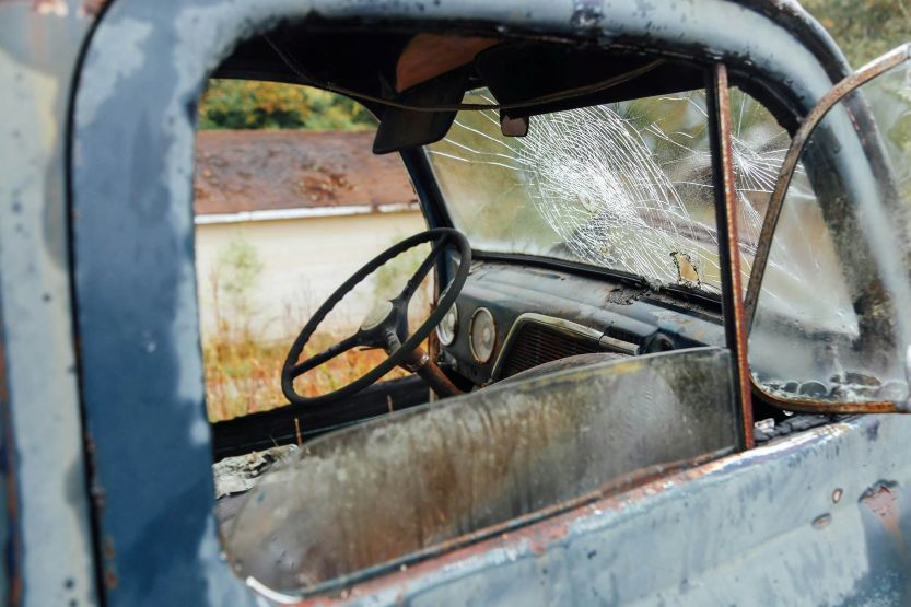 interior view of an abandoned salvage vehicle with a shattered windshield