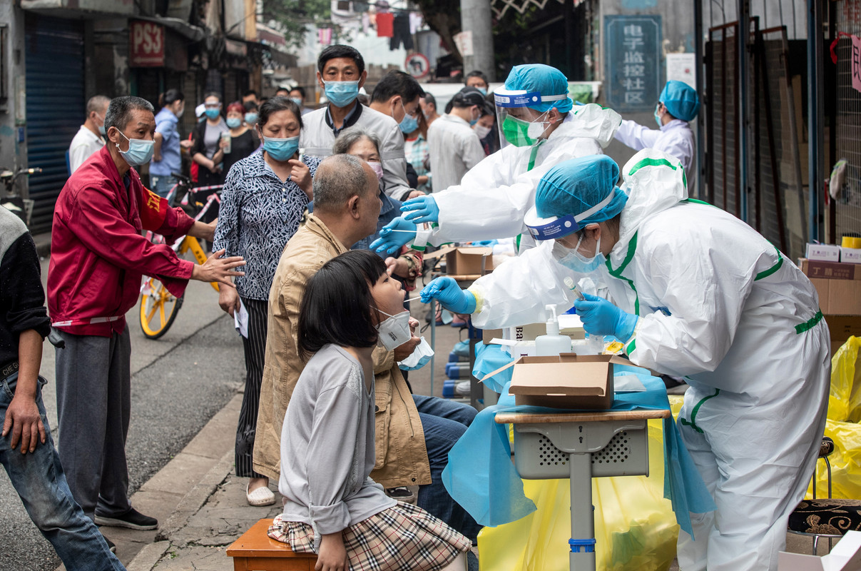 Foto file ini diambil pada 15 Mei 2020 menunjukkan pekerja medis mengambil sampel swab dari penduduk untuk diuji untuk virus corona COVID-19 di sebuah jalan di Wuhan di provinsi Hubei tengah Cina. Pihak berwenang China telah menyelesaikan kampanye pengujian coronavirus massal di Wuhan, menemukan hanya 300 hasil positif di antara hampir 10