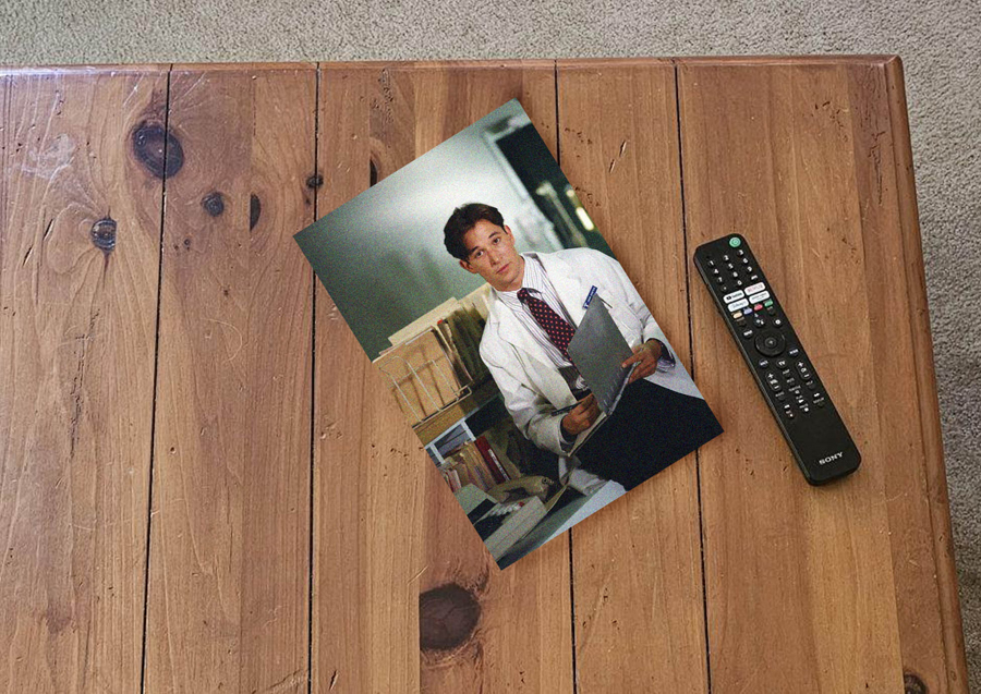 overhead photo of wooden coffee table with remote and picture of young Robby at work