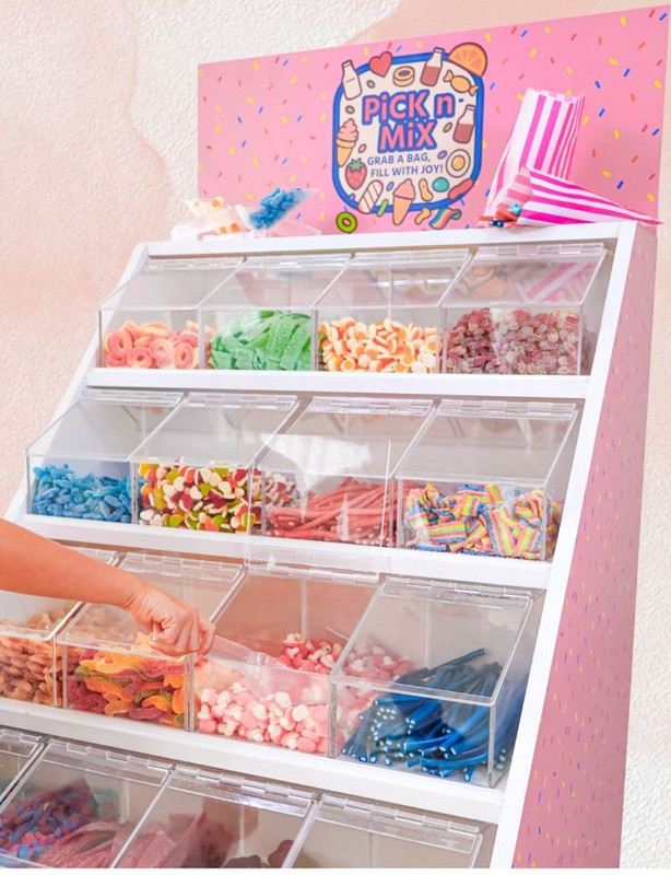 A guest filling up a pink and white striped candy bag
