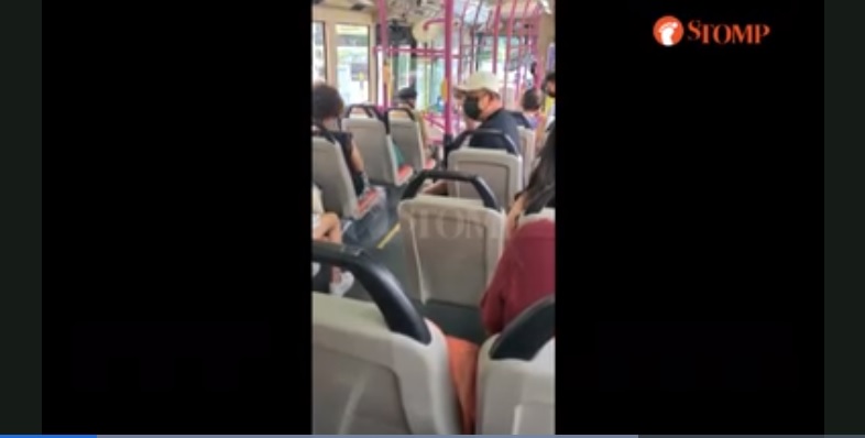 Tangkapan layar video penumpang pria marah dengan pasangan muda yang berpelukan dan pegangan tangan di bus.