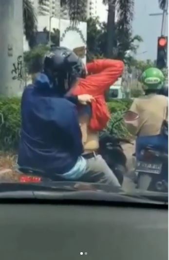 Sang wanita santai keroki pria di lampu merah
