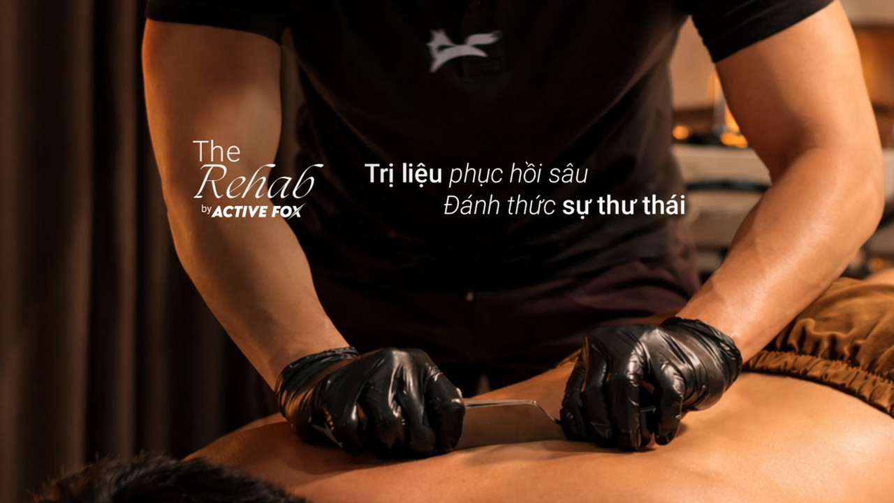 Chuyên viên thực hiện massage trị liệu The Rehab tại Active Fox, dùng dụng cụ hỗ trợ trên vùng lưng