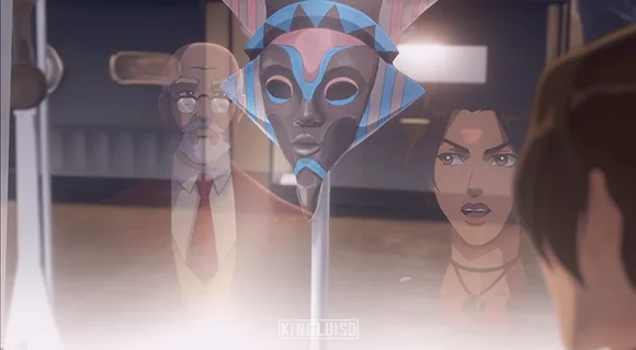 Lara mirando uno de los artefactos sagrados africanos que donó al Museo Británico de «Tomb Raider: La leyenda de Lara Croft». Lara Croft y el director de un museo británico observando una máscara Orisha robada y resguardada dentro de una exposición de la serie de Netflix: «Tomb Raider: La leyenda de Lara Croft», segunda temporada, capítulo uno