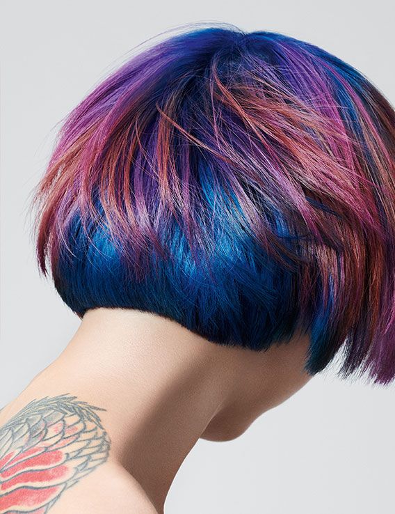 Tattooed girl with short jellyfish haircut in shades of red, purple and copper