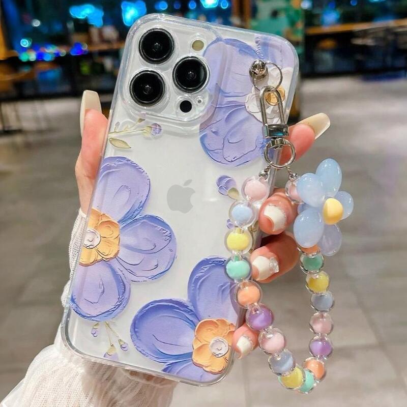 Foto de Funda transparente con diseño flora. Incluye correa de mano.