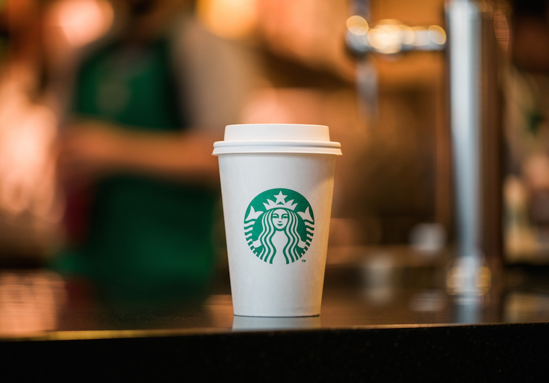 Barista Starbucks Kopi sedang menyajikan minuman untuk pelanggan