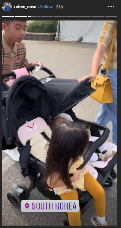 Betrand Peto mendorong stroller kedua adiknya