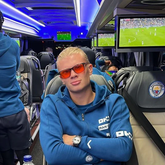 Haaland on the team bus wearing orange-tinted glasses