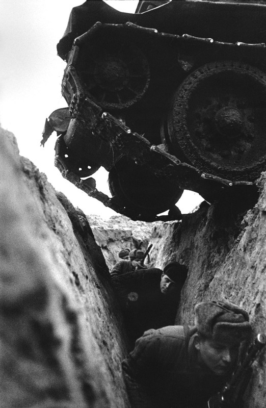 Soldados rusos se ponen a cubierto en sus trincheras, mientras columnas de T-34 se lanzan al ataque. Kursk, 1943