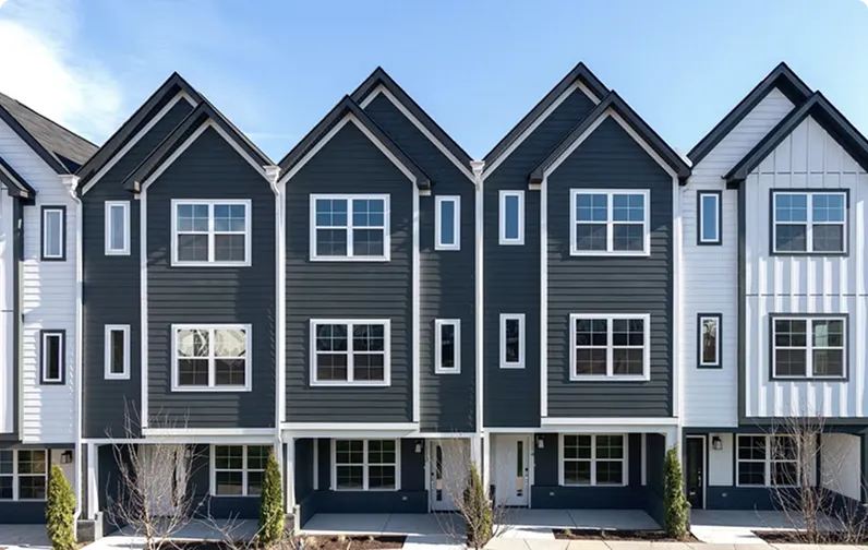 Row of three-story townhomes with dark gray and white siding