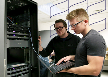 Students in information technology collaborate on a server rack.