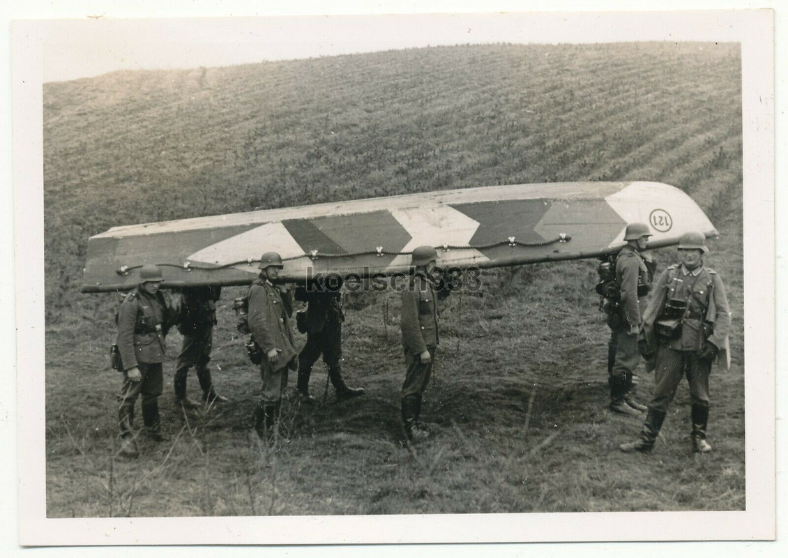 ! Foto Pioniere der Wehrmacht tragen ein Sturmboot mit Tarnung zu einem Gewässer