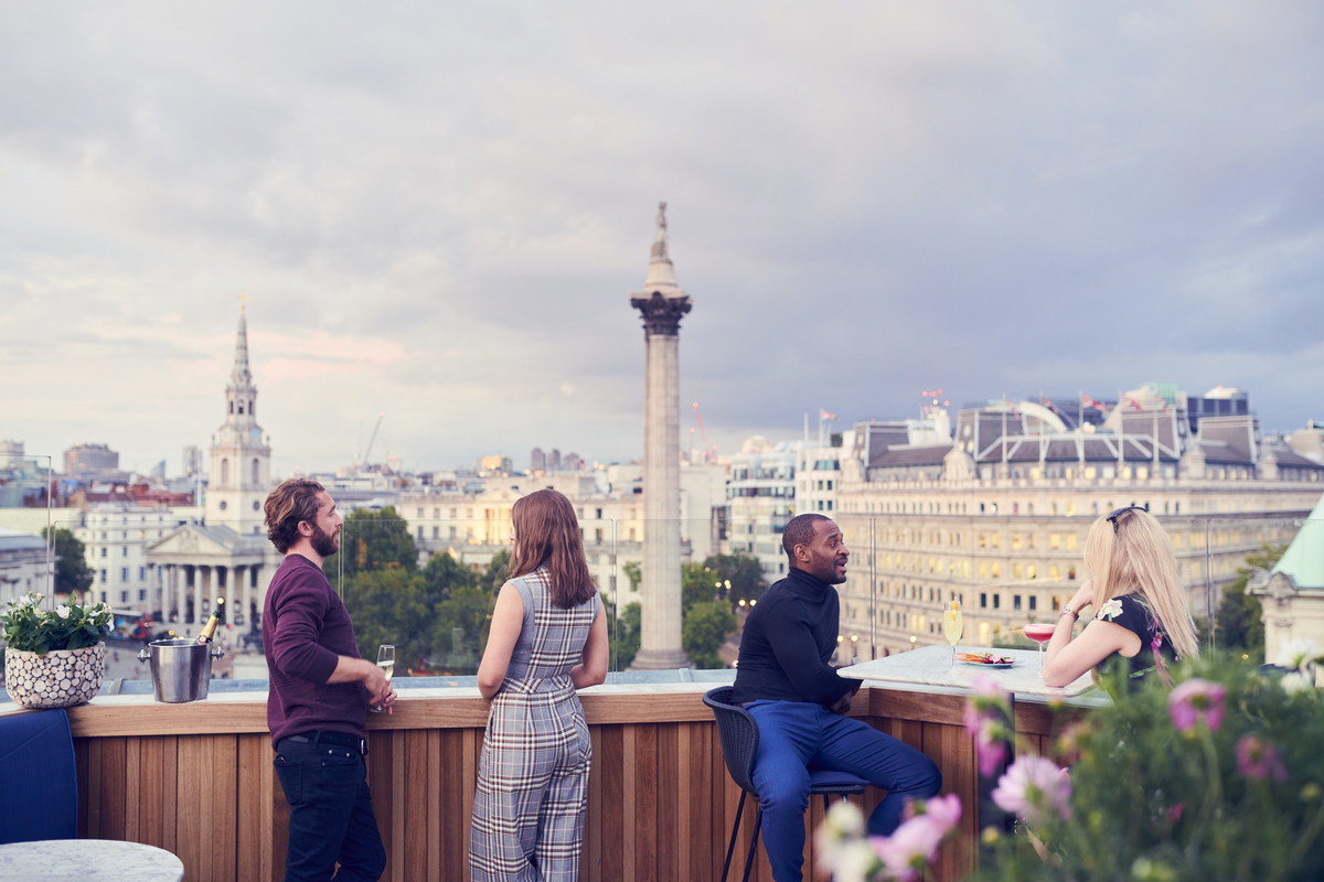 Ilustrasi wisatawan sedang menikmati suasana sore hari di rooftop bar di Inggris.