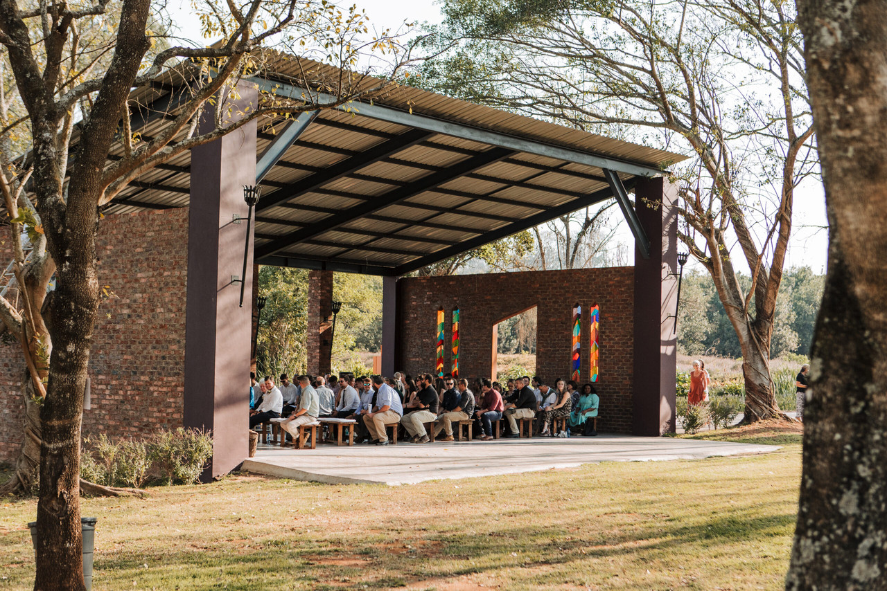 The open-sided chapel with a view of the dam, set up with wooden benches for a wedding ceremony.