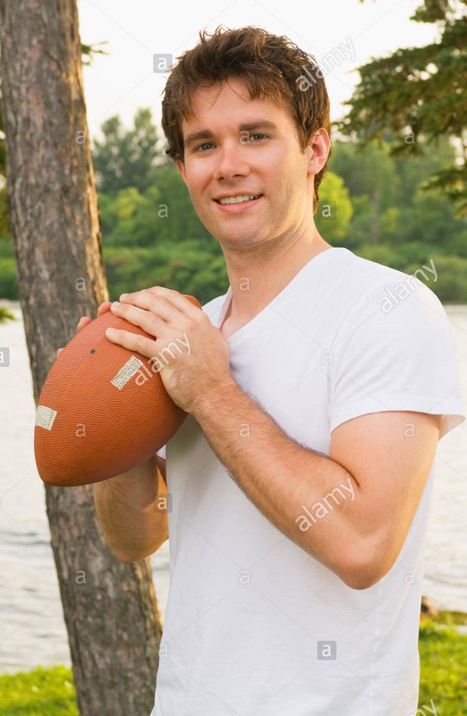 teenage-boy-holding-a-football-EEYD20.jpg
