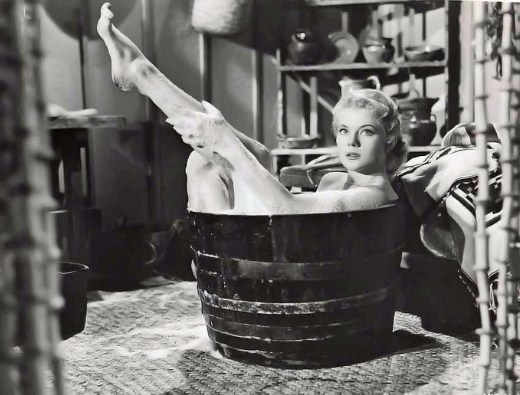 The White Orchid Promotional Still — Peggy Castle showcasing a flawless, washtub-framed barefoot profile