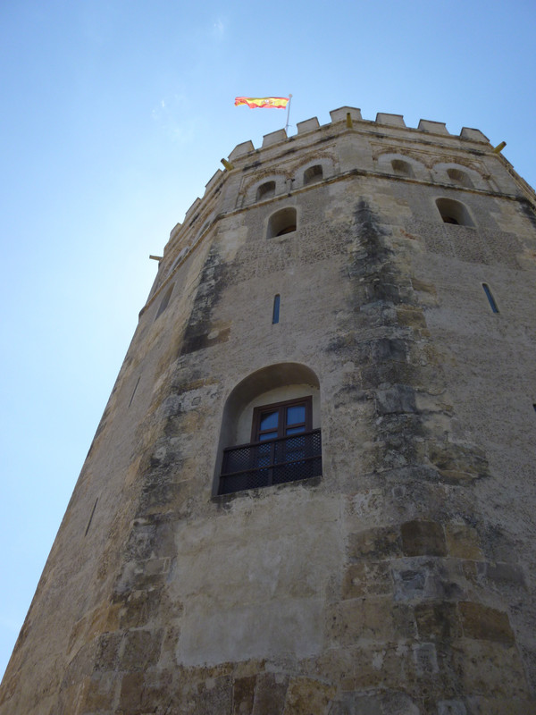 Photo of one side of the tower, looking up to the Spanish flag fluttering in the breeze.