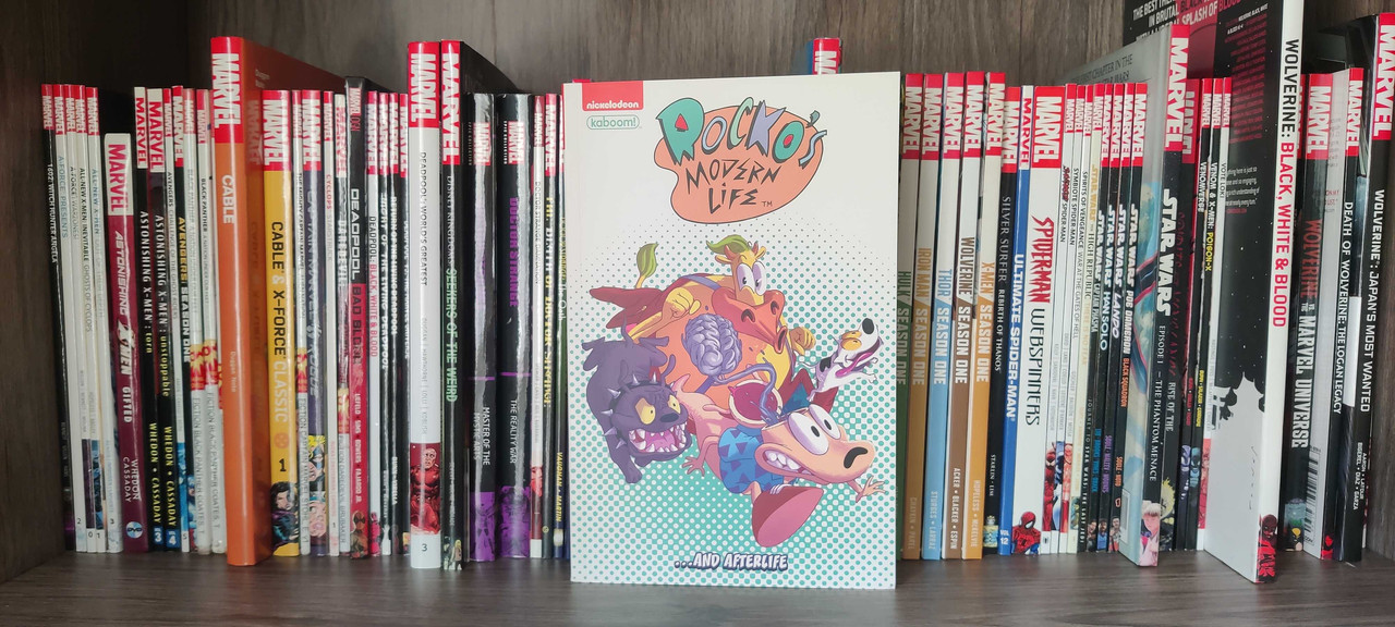The Rocko's Modern Life... and Afterlife graphic novel sitting on a bookshelf in front of other comic books.