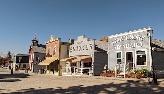 A street scene featuring multiple buildings and a prominent clock tower in the background.