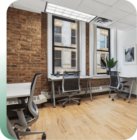 Rows of communical desks in large suite area.