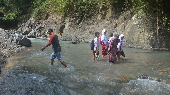 Warga menyeberangi Sungai Mondo yang memisahkan Dusun Punggung, Desa Duren dan Desa Lebakwangi, Kecamatan Pagedongan, Banjarnegara, Jawa Tengah, Senin (18/7/2022).