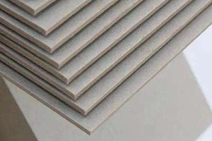 Thick, glossy laminated paper boards stacked neatly.
